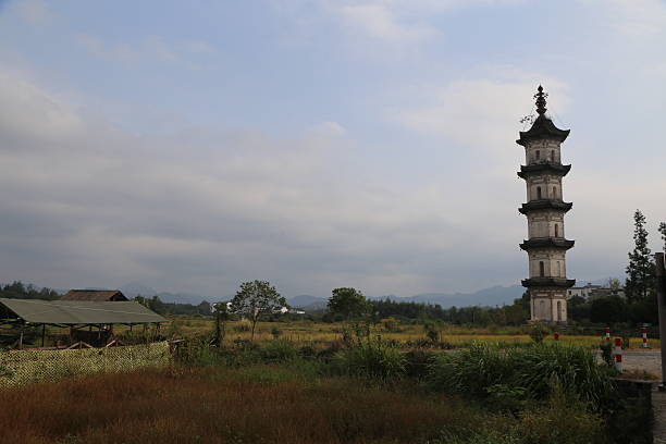 istock a stone tower stands in the middle of an open field, surrounded by rice fields and distant mountains. 2243890581