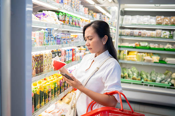 istock Woman shopping for drinks in supermarket refrigerator section 2243891950