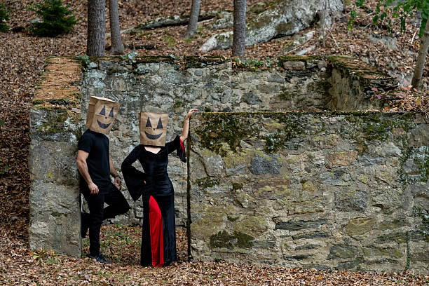 Couple dressed for halloween having fun in the woods and colorful fall foliage as a natural background