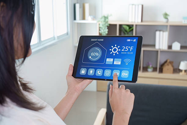 istock Smart Home. Woman controlling smart home system on tablet. 2243893211