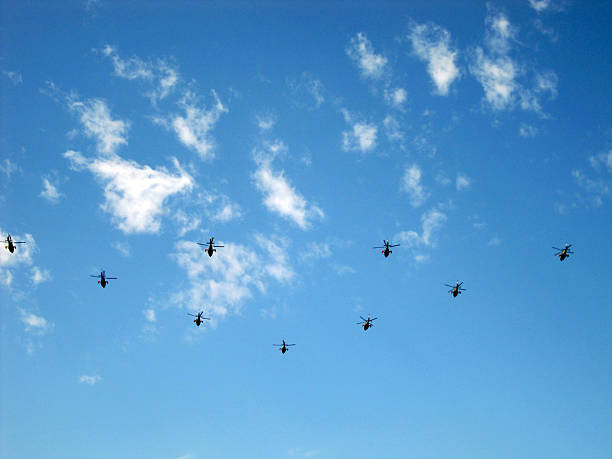 istock Helicopters Flying in a Clear Blue Sky with Some Clouds 2243895695
