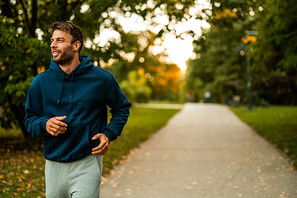 istock Happy athletic man jogging through the park. 2243896085