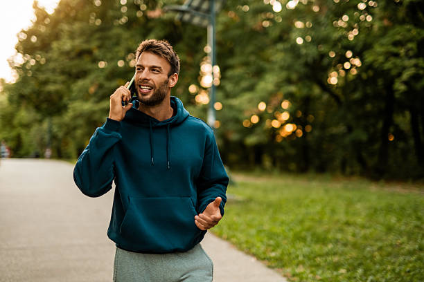 istock Happy athletic man using phone after jogging through the park. 2243896160