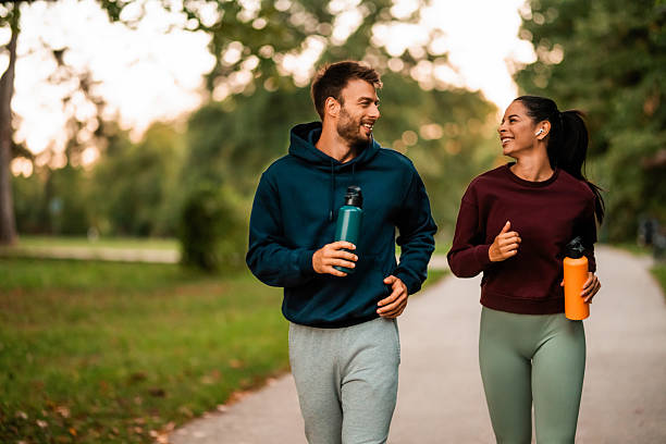 istock Cheerful athletic couple jogging through the park. 2243896228