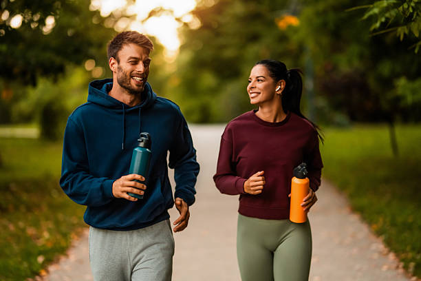 istock Cheerful athletic couple jogging through the park. 2243896268
