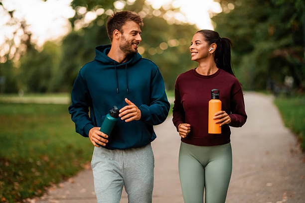 istock Cheerful athletic couple jogging through the park. 2243896296