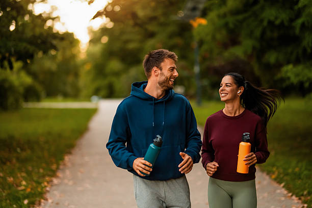 istock Cheerful athletic couple jogging through the park. 2243896334
