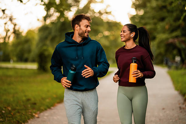 istock Cheerful athletic couple jogging through the park. 2243896919