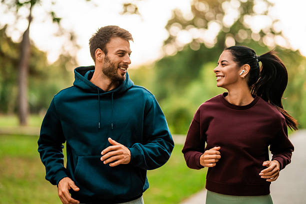 Happy athletic couple having fun while running together in nature.