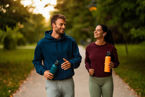 Happy athletic couple having fun while running together in nature.