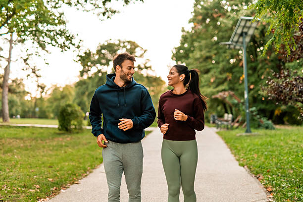 istock Cheerful athletic couple jogging through the park. 2243897048