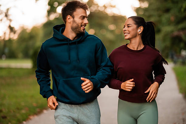 istock Cheerful athletic couple jogging through the park. 2243897107