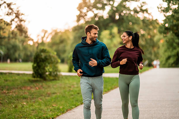 istock Cheerful athletic couple jogging through the park. 2243897111