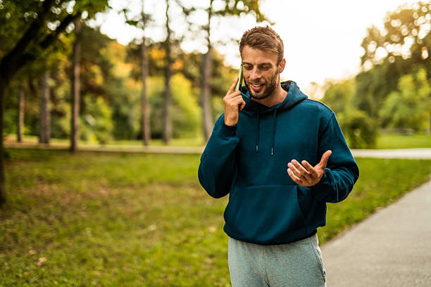 istock Happy athletic man using phone after jogging through the park. 2243897161