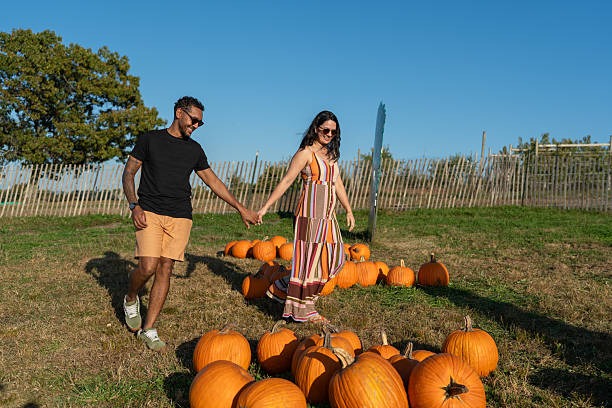 istock Couple picking pumpkins for Halloween 2243898416