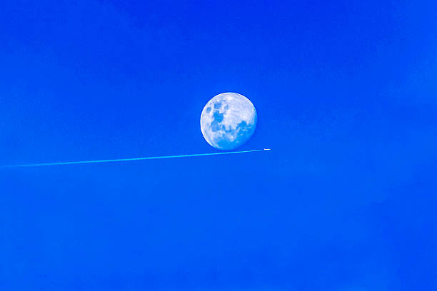 The moon and a fleeting contrail against a vibrant blue canvas in Sydney, NSW, Australia (Photo by Tara Chand Malhotra)