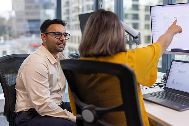 istock Corporate colleague discussion at a desk with a computer 2243908051