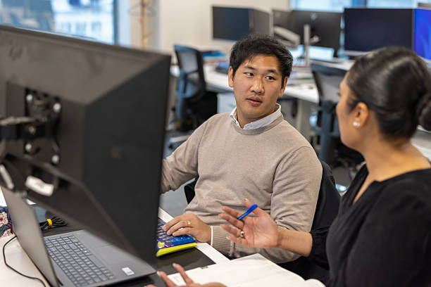 istock Corporate colleague discussion at a desk with a computer 2243908063