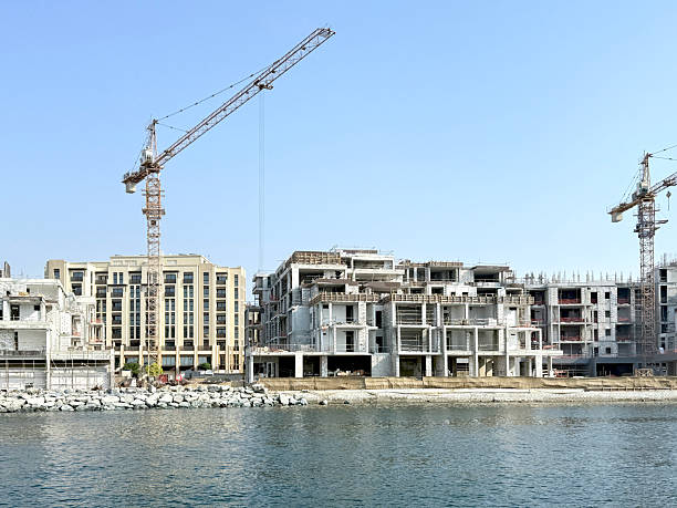 istock Seafront apartment buildings under construction with cranes, scaffolding. Waterfront real estate development concept. 2243909836
