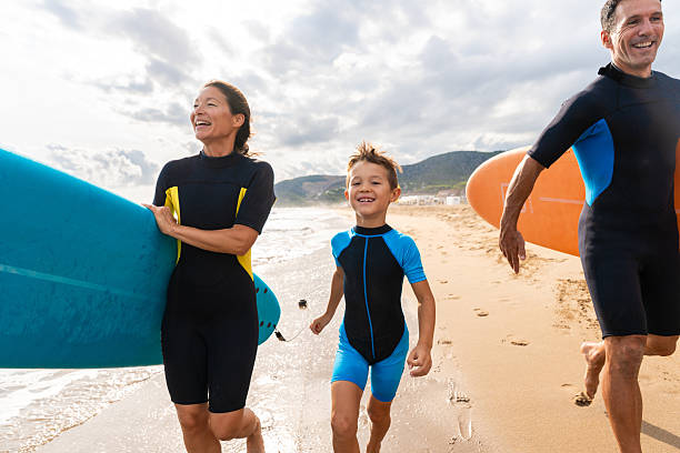 istock Family learning surfing enjoying beach vacation together 2243910709