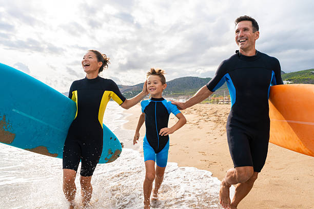 istock Family learning surfing enjoying beach vacation together 2243910718