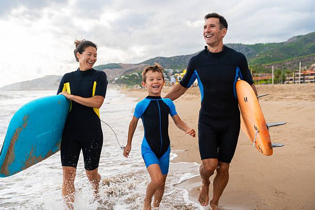 istock Family learning surfing enjoying beach vacation together 2243910777