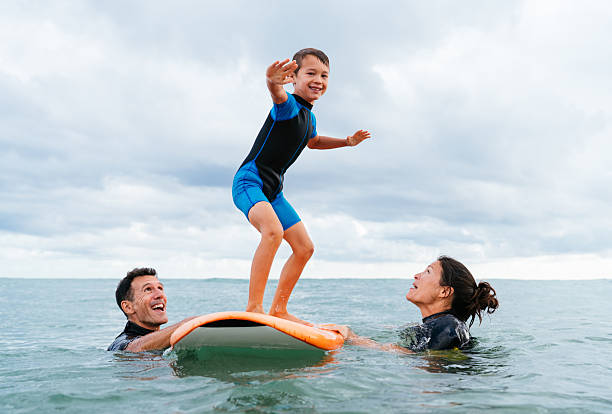 istock Parents teaching child surfing lesson in ocean 2243910813
