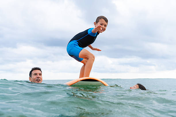 istock Parents teaching child surfing lesson in ocean 2243910818