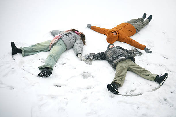 istock Family Making Snow Angels Outdoors during Winter Daytime 2243911064