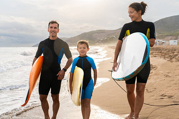 istock Family enjoying summer beach vacation learning surfing 2243911187