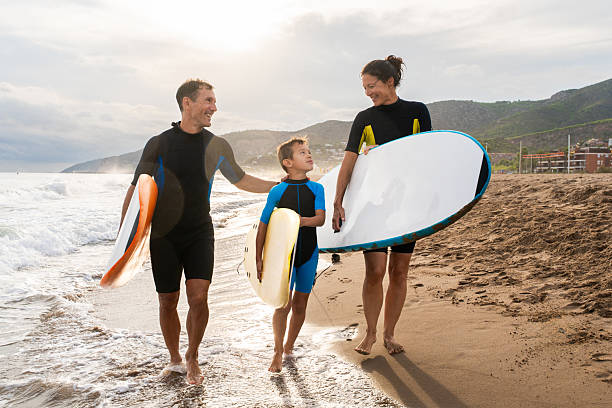 istock Family enjoying summer beach vacation learning surfing 2243911199