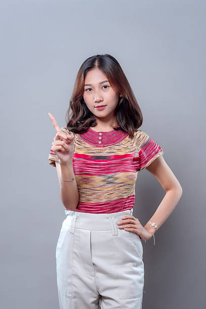 istock Confident Asian Woman Pointing Up with Serious Expression 2243913790