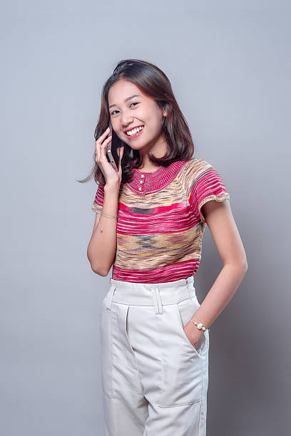 istock Smiling Asian Woman Talking on Mobile Phone 2243914369