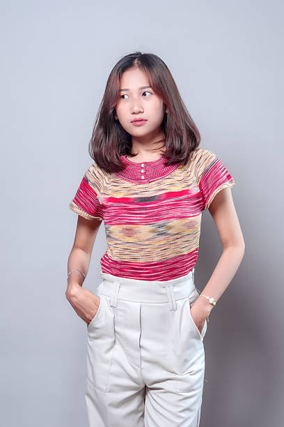 istock Thoughtful Asian Woman with Hands in Pockets 2243914671