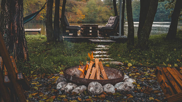 istock Cozy lakeside campfire scene with seating area and autumn foliage 2243919347