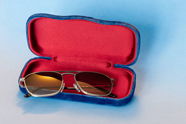istock Stylish glasses in blue case with red velvet interior shown on smooth gradient blue backdrop 2243921722