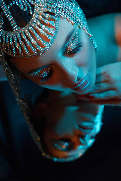 Studio shot of glamorous woman illuminated by blue and purple lights