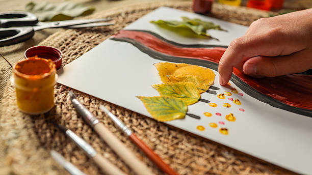 istock Artistic autumn leaf painting with hand 2243923278