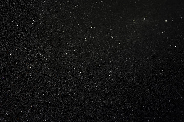 istock Black texture with golden inclusions and rare sparkles, abstract surface glowing subtly with scattered highlights across dark granular depth 2243923310