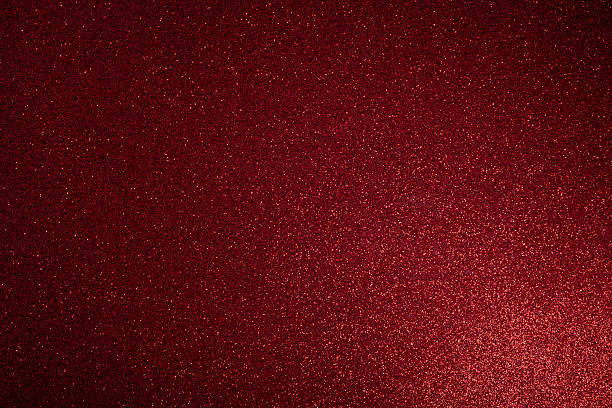 istock Deep red glitter surface glowing from lower right with macro texture and evenly scattered sparkles 2243923428
