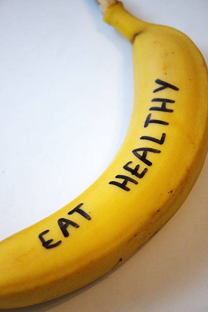 istock Yellow banana with Eat healthy text on white background, close-up, Copy Space 2243924621