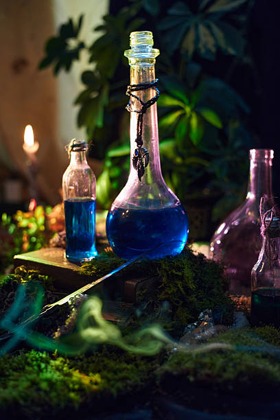 istock Various glass bottles containing bright blue liquid are arranged on a surface covered in lush moss. atmosphere is softly illuminated by candlelight, highlighting the natural surroundings 2243925765