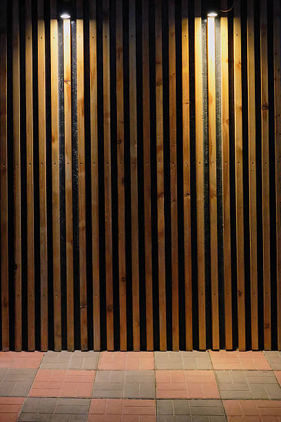 istock Vertical wooden slats on wall with overhead lights and brick floor 2243926330