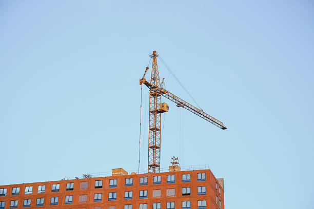 construction of a modern apartment building: crane against blue sky 1