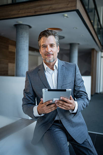 istock Mature businessman holding digital tablet in modern office 2243928863