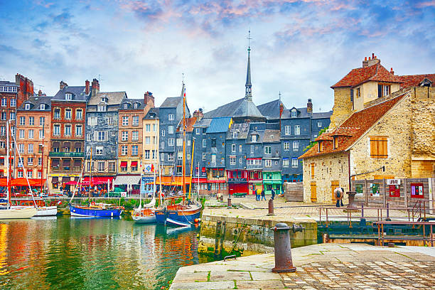 Colorful historic houses reflected in the calm waters of Honfleur harbor, France
