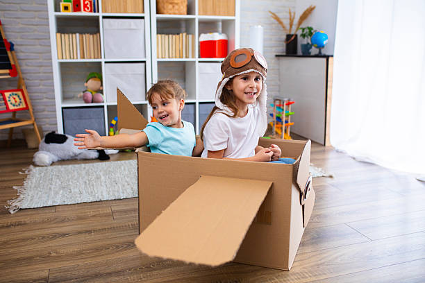 istock Little pilot and passenger play joyfully in a cardboard airplane, symbolizing creativity and friendship 2243930749