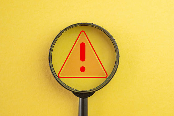 istock Risk Assessment Concept: Magnifier Focusing on Warning Alert Icon 2243931010