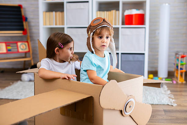 istock Little pilot and passenger play joyfully in a cardboard airplane, symbolizing creativity and friendship 2243931035