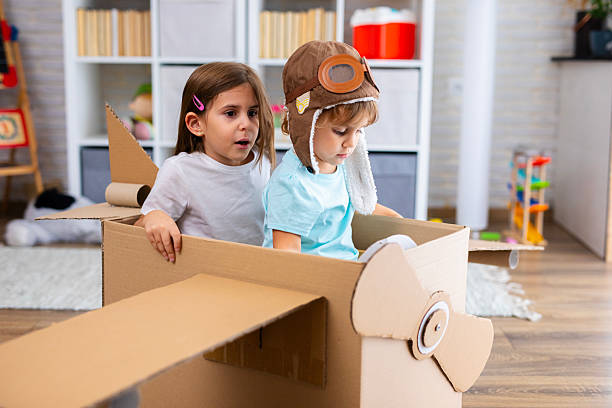 istock Little pilot and passenger play joyfully in a cardboard airplane, symbolizing creativity and friendship 2243931064